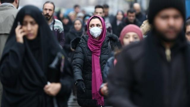 An Iranian woman wearing a protective mask to prevent contracting a coronavirus walks at Grand Bazaar in Tehran