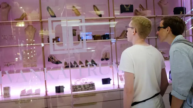 Personas admirando una vitrina de una tienda de Ivanka Trump