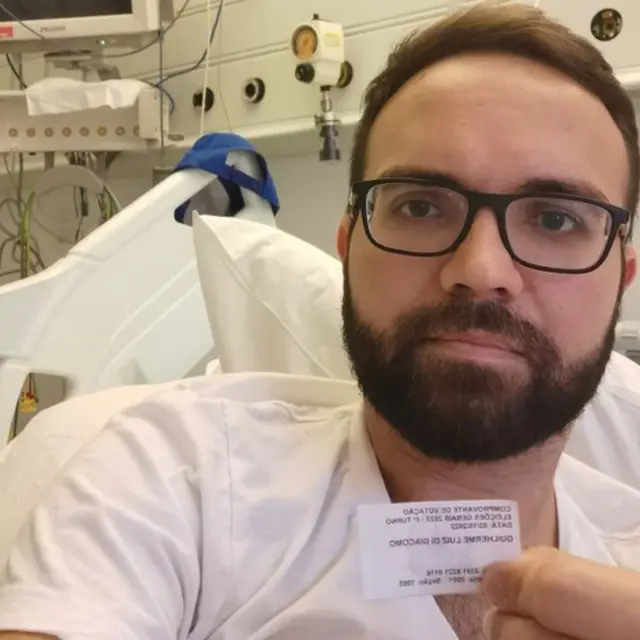 Pulseira de hospital e comprovante de votação de Guilherme Di Giacomo