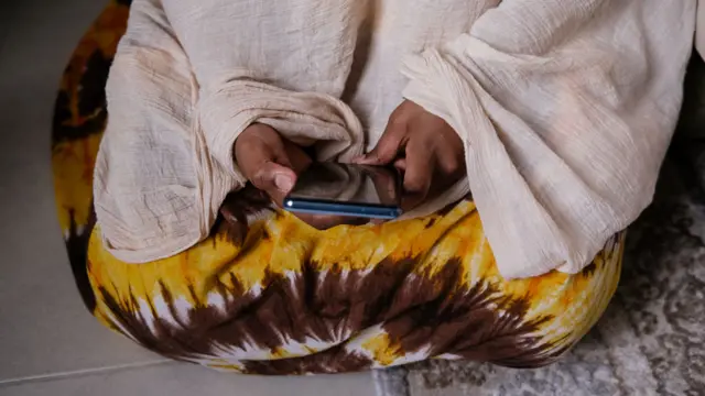 امرأة تحمل الهاتف