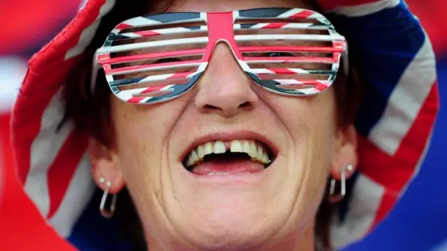 Una persona con un sombrero y lentes con la bandera de Reino Unido