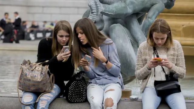 스마트폰을 들여다 보는 청소년들