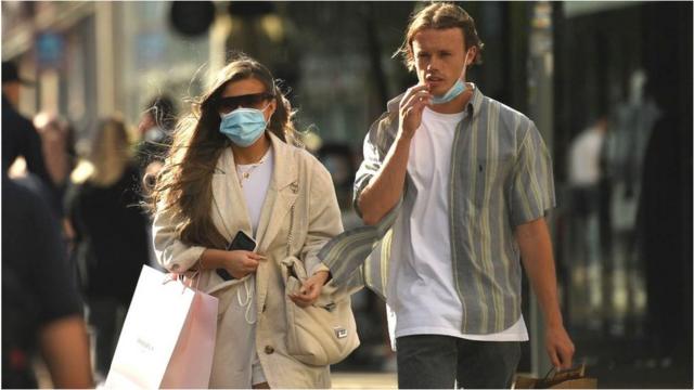 A couple wearing face coverings in Manchester City Centre