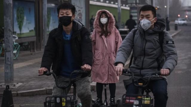 People wear protective masks as they ride in the street during the rush hour on February 10, 2020 in Beijing