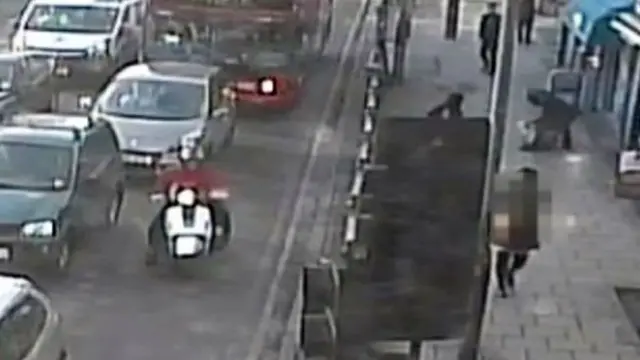 двое на мотороллере в потоке движения