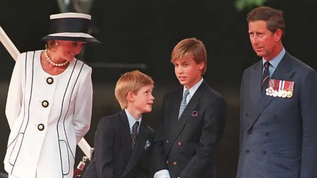Princess Diana(L), her sons Harry(2nd L) and William(2nd R), and Prince Charles(R) watch the parade march past as part of the commemorations of VJ Day 19 August in London.