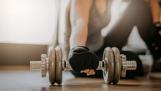 Una mujer agarrando una pesa.