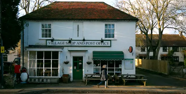 Jo Hamilton pasando frente a la oficina de correos que gestionaba.