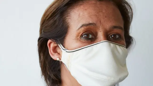 Una mujer usa una mascarilla de The Copper Company