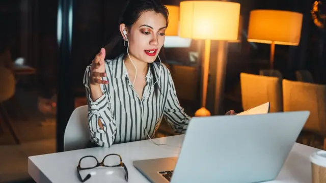 Femme travaillant à domicile. Elle utilise un ordinateur portable pour une réunion d'affaires.