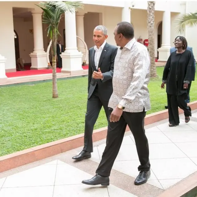 Bw Obama na Bw Kenyatta wakitembea ikulu, Nairobi. Nyuma yao ni Bi Auma Obama