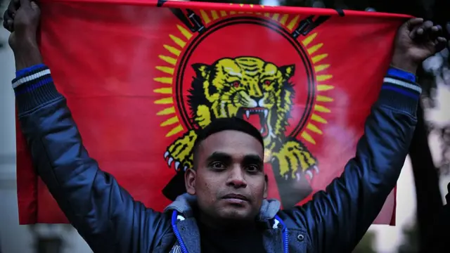 லண்டனில் நடந்த போராட்டம் ஒன்றில் விடுதலைப் புலிகள் அமைப்பின் கொடியைப் பிடித்திருக்கும் தமிழர் ஒருவர்.