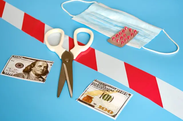 Tijeras y un billete de US$100 cortado