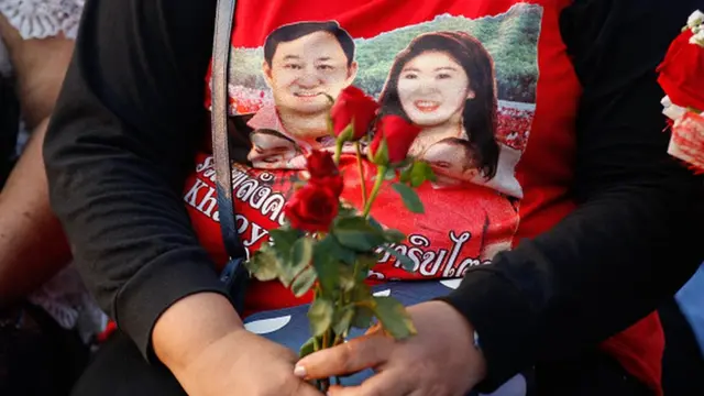 تصویر تاکسین شیناواترا و خواهرش ینگلاک شیناواترا بر روی تیشرت یکی از هواداران حزب "برای تایلندیها". هر دوی این سیاستمدارها در کودتای نظامی از قدرت برکنار شدهاند