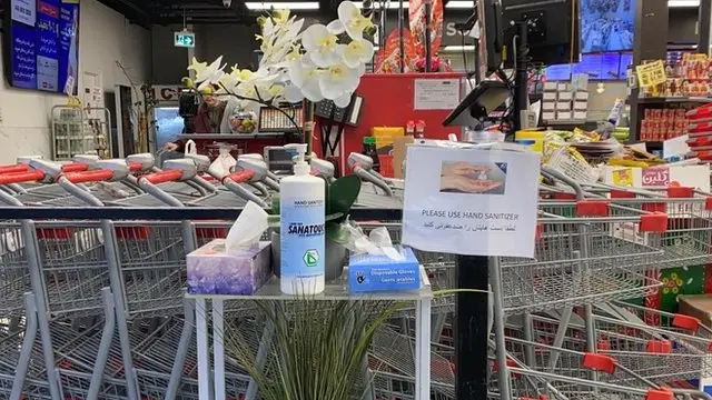 در ورودی فروشگاه میزی با مواد ضدعفونی کننده و دستکش برای مشتری‌های گذاشته شده است