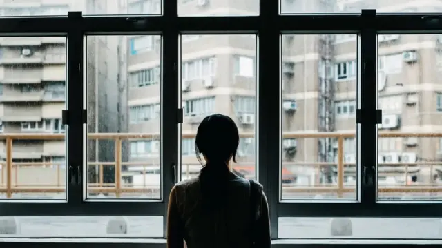 Mulher observando o mundo exterior atravésmelhores site aposta esportivauma janela