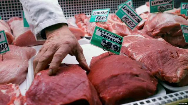 Мясник раскладывает мясо на рынке в Польше