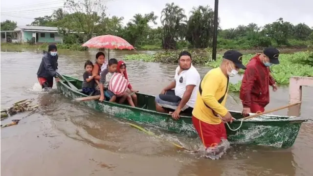 Bomberos rescatan una familia en Honduras por la crecida del río.