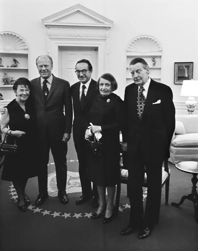رُز گلدسمیت مادر آلن گرین‌اسپن، جرالد فورد رئیس جمهور آمریکا، آلن گرین‌اسپن آین رند و شوهرش چارلز فرانسیس اُکانر در دفتر بیضی کاخ سفید، 1974