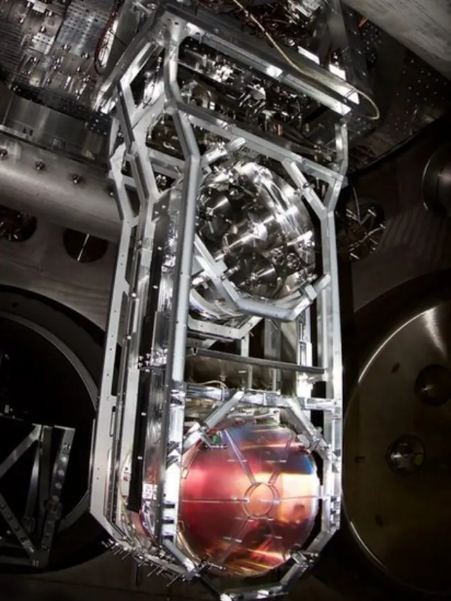 Uno de los espejos suspendidos como péndulos en los que rebotan los láseres, dentro de los túneles de cuatro kilómetros de largo.