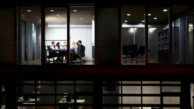 Unas personas trabajando en una oficina hasta tarde