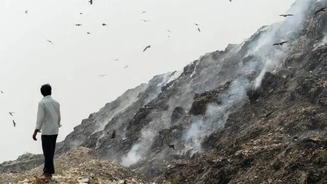 Hombre en basural en Bangladesh.
