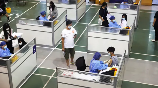 Alumnos de un colegio en Shanghái reciben la vacuna contra el covid-19.