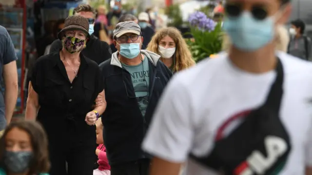 Pessoas caminhando na ruaarena f12betmáscara