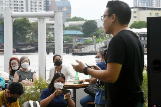 กลุ่มคนใส่หน้ากากกำลังนั่งฟัง