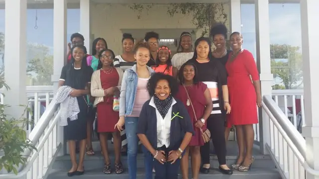 መንበረ እየከፈለች ከምታስተምራቸው ልጆች ጋር በምግብ ቤቷ ደጃፍ