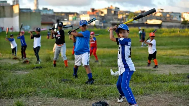 Niños cubanos juegan béisbol