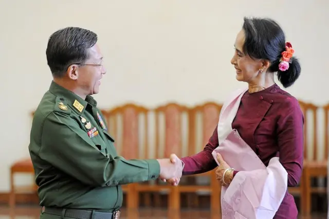 El comandante en jefe de Myanmar, Min Aung Hlaing, le estrecha la mano y le sonríe a Aung San Suu Kyi en Naypyidaw el 2 de diciembre de 2015.