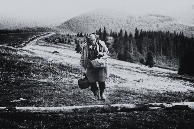 امراة عجوز تمشي في طريق وعرة