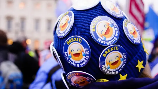 Chapas que dicen "el Brexit no está saliendo tan bien, ¿no?" en el gorro de una persona