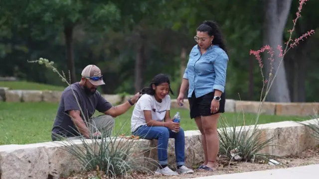 Una menor es consolada por dos adultos en el Centro Willie de León luego del tiroteo.