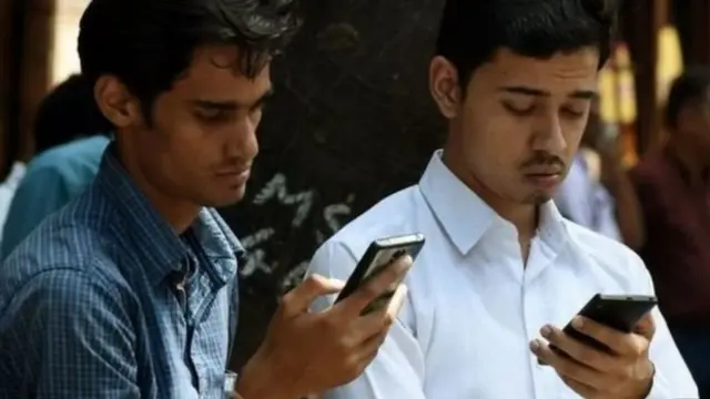 स्मार्ट फ़ोन देखते लोग