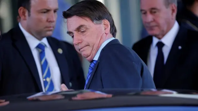 O presidente Jaird Bolsonaro saindounique casinoum carro, com seguranças atrás