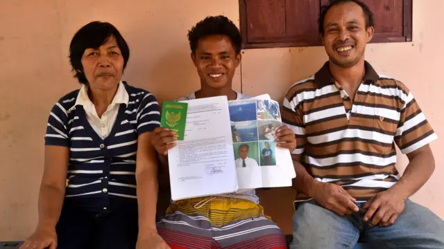 Aldi Novel Adilang poses with parent as he shows his pictures of being rescued by the Japanese Coast Guards in North Minahasa