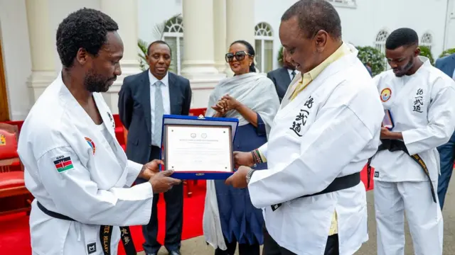 Pirezidaanti Uhuuruu Keeniyaataa qabattootto gurraacha digirii 8ffaa kabajaa maarshaal aartii yeroo fudhatan.