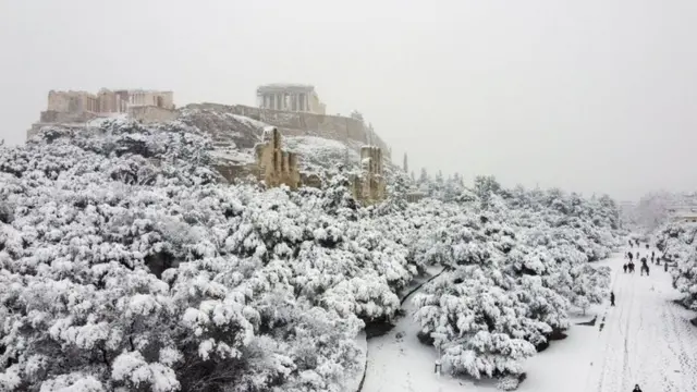 The Parthenon temple is seen atop the Acropolis hill archaeological site during a heavy snowfall in Athens, Greece