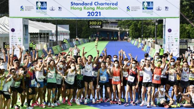 香港維多利亞公園內群眾跑手們在渣打香港馬拉松衝線處合影留念（中新社圖片24/10/2021）
