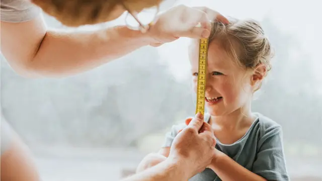 Mulher colocando fita métrica no rosto7games app baixaruma menina