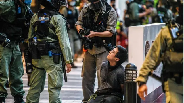 হংকং-এ পুলিশের হাতে আটক একজন বিক্ষোভকারী।