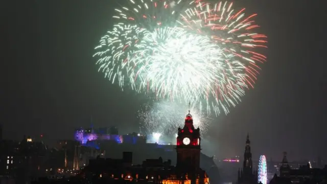Fogos de artifício explodem sobre o Castelo de Edimburgo durante a festa de rua para as comemorações do Ano Novo Hogmanay em Edimburgo