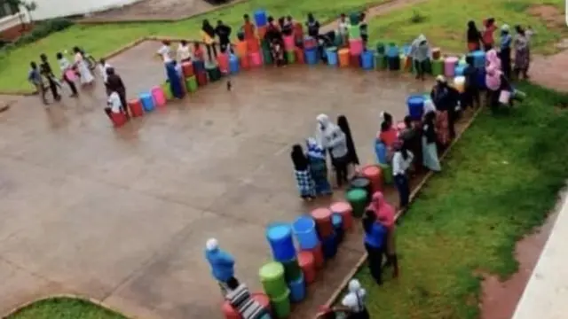 Wanafunzi wakiwa wamepanga mstari kukinga maji