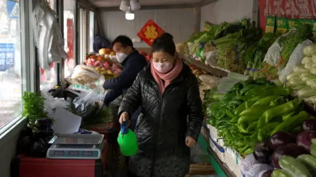 продавщица дизенфицирует овощи