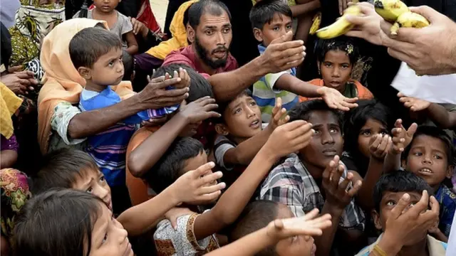 ผู้อพยพโรฮิงญารับกล้วยจากอาสาสมัครชาวบังกลาเทศหลังหนีออกมาจากเมียนมา