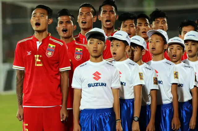 ရန်ကုန်မှာ ကျင်းပတဲ့ ၂၀၁၆ အာရှဘောလုံးအဖွဲ့ချုပ် ဆူဇူကီးဖလားပြိုင်ပွဲ အုပ်စုပွဲမှာ နိုင်ငံတော်သီချင်း သီဆိုနေတဲ့ မြန်မာအသင်းသားတွေနဲ့ ကလေးငယ်တွေ