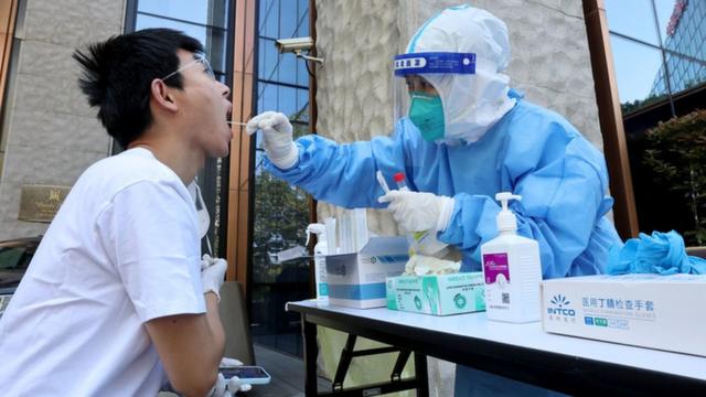一名医务工作者从一名男子身上采集拭子样本以检测Covid-19冠状病毒