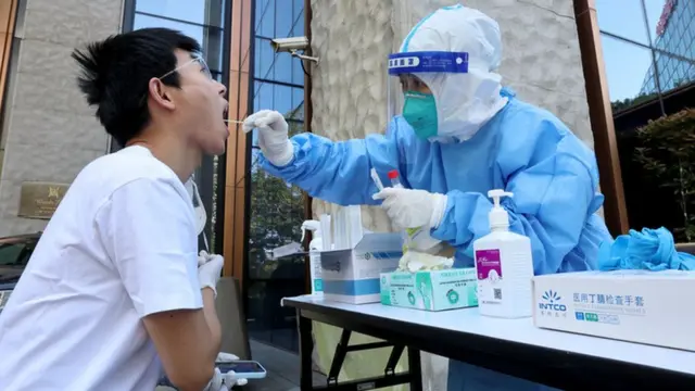 一名医务工作者从一名男子身上采集拭子样本以检测Covid-19冠状病毒